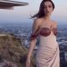 A woman in Imani Blush Pink and Copper Corset Two-Piece Dress standing on top of a hill.