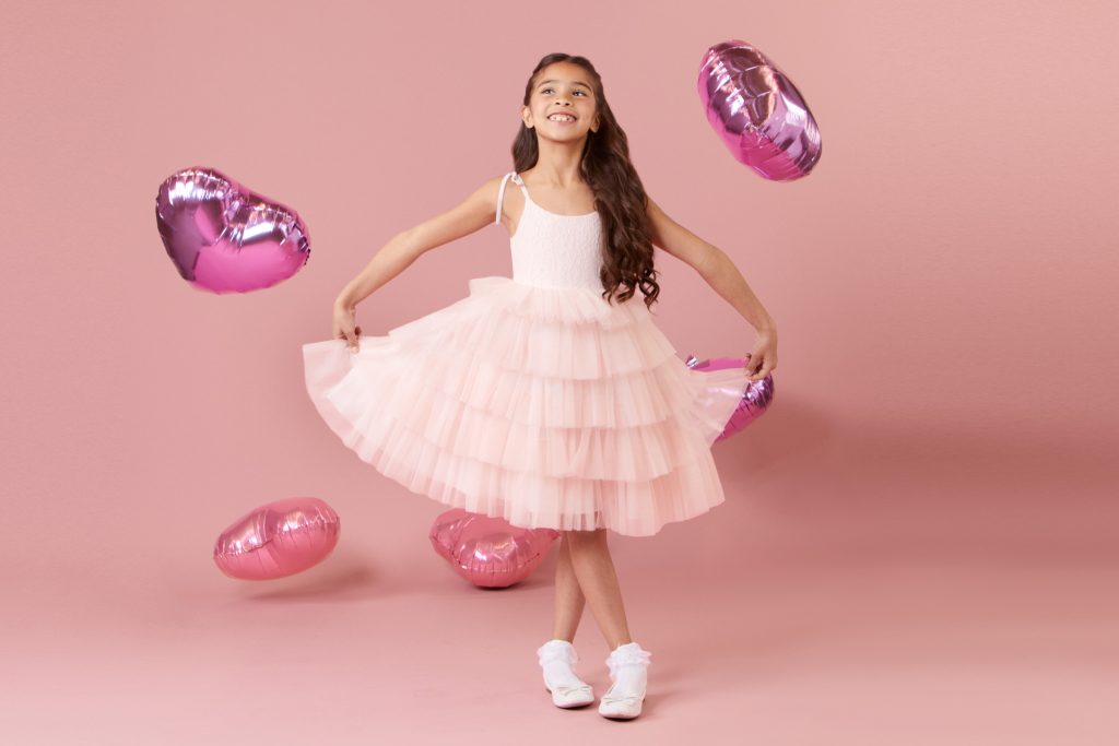 Flower girl in a fun light pink layered skirt dress